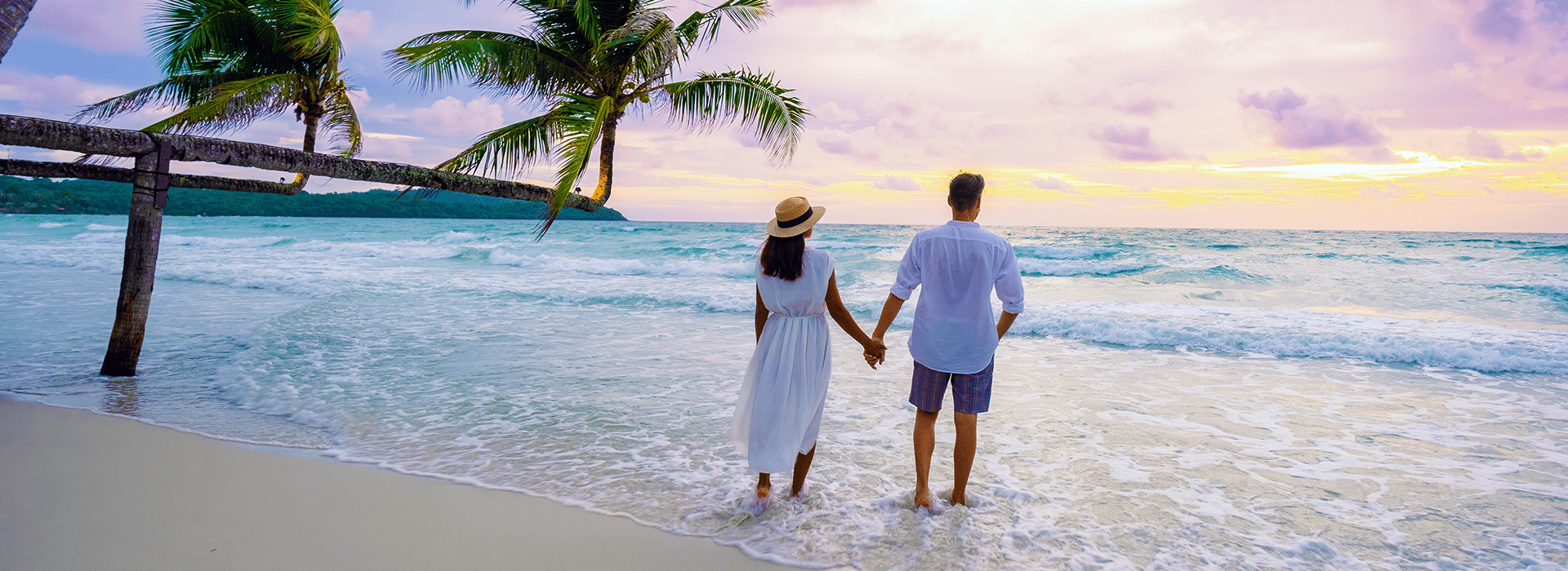 Couple holding hands on the beach.